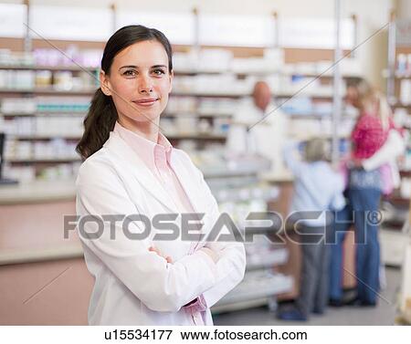 Smiling pharmacist standing in store View Large Photo Image Stock Photo - Smiling pharmacist standing in store. Fotosearch