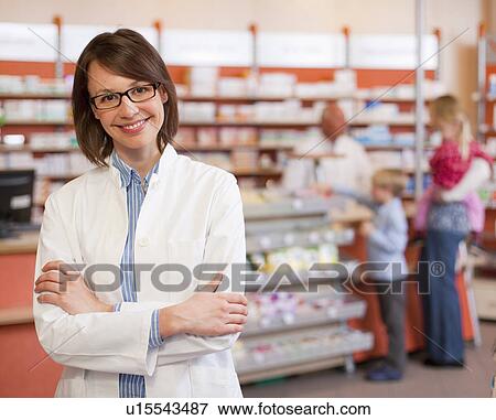 Smiling pharmacist standing in store View Large Photo Image Stock Photo - Smiling pharmacist standing in store. Fotosearch
