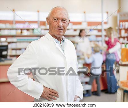 Smiling pharmacist standing in store View Large Photo Image Stock Photo - Smiling pharmacist standing in store. Fotosearch