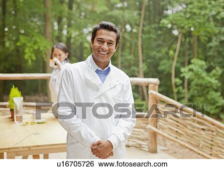 Stock Photograph - Smiling scientist standing on balcony. Fotosearch