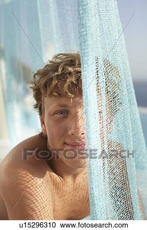 Smiling teenage boy playing with fabric View Large Photo Image Stock Image - Smiling teenage boy playing with fabric. Fotosearch