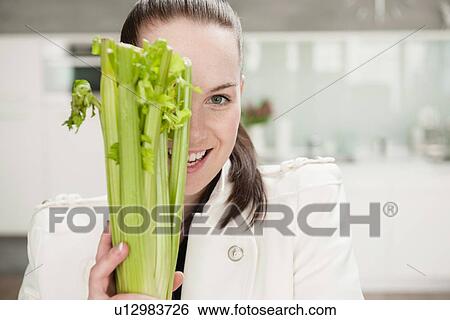 Smiling woman holding head of celery View Large Photo Image Stock Photograph - Smiling woman holding head of celery. Fotosearch