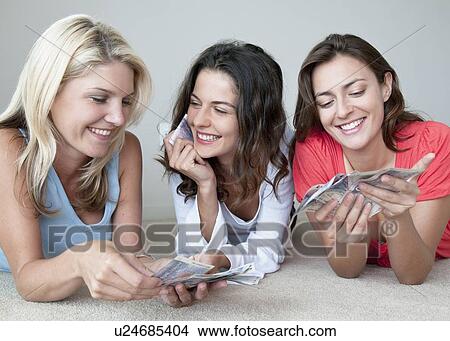 Picture - Smiling women counting money together. Fotosearch