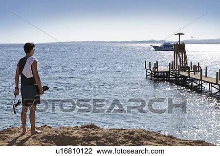 Snorkeler carrying fins on sandy beach View Large Photo Image Stock Image - Snorkeler carrying fins on sandy beach. Fotosearch
