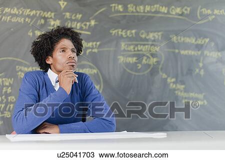 Stock Image - Student listening at desk in class. Fotosearch