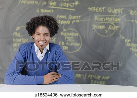Stock Photograph - Student sitting at desk in class. Fotosearch