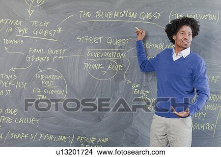 Teacher pointing to chalkboard View Large Photo Image Picture - Teacher pointing to chalkboard. Fotosearch