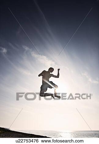Stock Photograph - Teenage boy posing in mid-air. Fotosearch