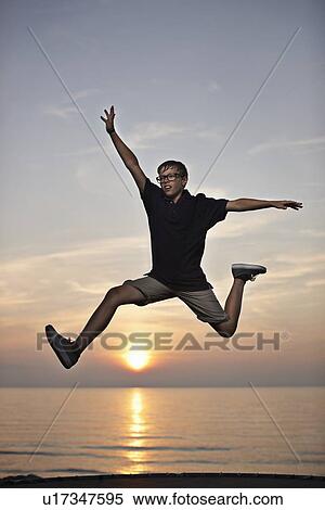 Teenage boy posing in mid-air View Large Photo Image Stock Photography - Teenage boy posing in mid-air. Fotosearch
