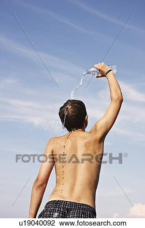 Teenage boy pouring water on himself View Large Photo Image Stock Image - Teenage boy pouring water on himself. Fotosearch