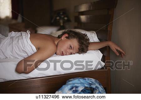 Teenage boy relaxing in bed View Large Photo Image Stock Photograph - Teenage boy relaxing in bed. Fotosearch
