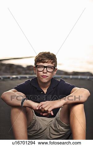 Picture - Teenage boy sitting on trampoline. Fotosearch