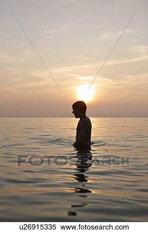 Teenage boy standing in water View Large Photo Image Stock Photography - Teenage boy standing in water. Fotosearch