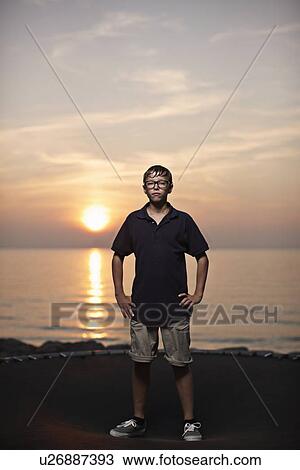 Teenage boy standing on trampoline View Large Photo Image Stock Image - Teenage boy standing on trampoline. Fotosearch