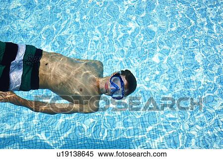 Stock Photography - Teenage boy wearing goggles in pool. Fotosearch