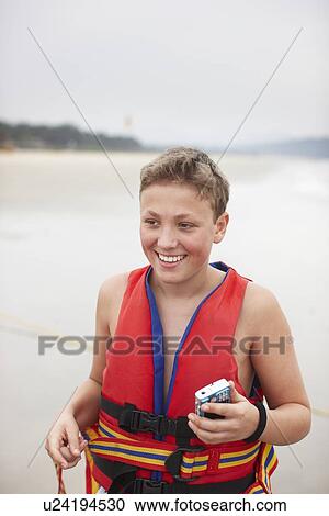 Teenage boy wearing life vest on beach View Large Photo Image Stock Image - Teenage boy wearing life vest on beach. Fotosearch