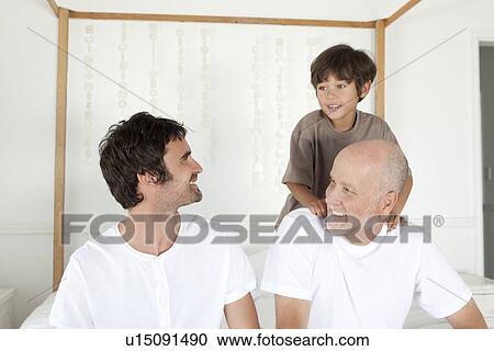 Three generations of men on bed View Large Photo Image Stock Image - Three generations of men on bed. Fotosearch