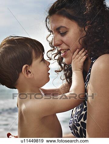 Stock Photo - Toddler boy holding mothers face. Fotosearch