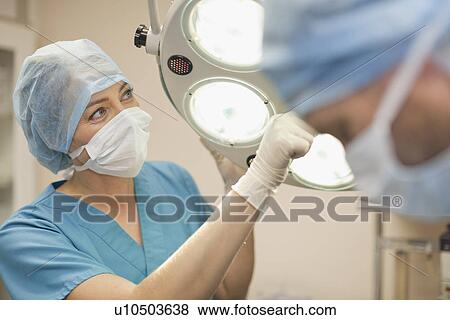 Stock Photo - Veterinary surgeon adjusting lights. Fotosearch