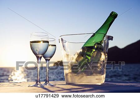 Stock Photo - Wine glasses and bottle outdoors. Fotosearch