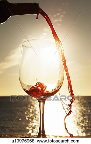 Wine spilling from bottle outdoors View Large Photo Image Stock Photo - Wine spilling from bottle outdoors. Fotosearch