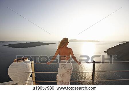 Stock Image - Woman admiring ocean view from balcony. Fotosearch