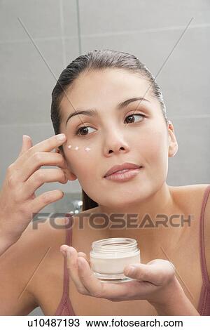 Woman applying moisturizer to face View Large Photo Image Stock Image - Woman applying moisturizer to face. Fotosearch