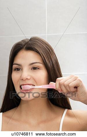 Woman brushing her teeth in mirror View Large Photo Image Stock Image - Woman brushing her teeth in mirror. Fotosearch