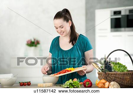 Woman chopping vegetables in kitchen View Large Photo Image Stock Image - Woman chopping vegetables in kitchen. Fotosearch