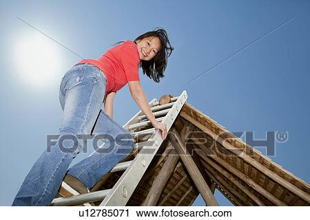Woman climbing to roof of log hut View Large Photo Image Stock Image - Woman climbing to roof of log hut. Fotosearch