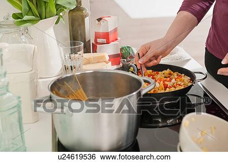 Stock Photograph - Woman cooking in kitchen. Fotosearch