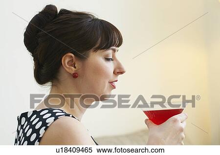 Woman drinking cocktail in living room View Large Photo Image Stock Photography - Woman drinking cocktail in living room. Fotosearch
