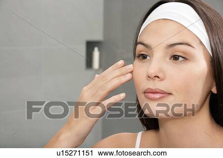 Woman examining her face in mirror View Large Photo Image Stock Image - Woman examining her face in mirror. Fotosearch