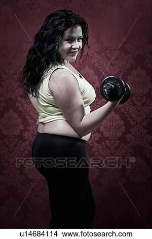 Woman lifting weights at home View Large Photo Image Picture - Woman lifting weights at home. Fotosearch