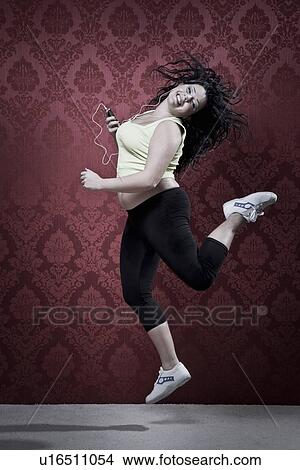Woman listening to headphones in workout View Large Photo Image Picture - Woman listening to headphones in workout. Fotosearch