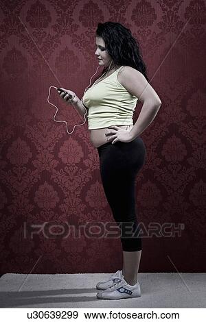 Stock Photo - Woman listening to headphones in workout. Fotosearch