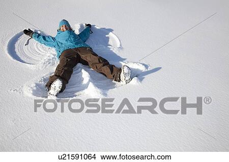 Woman making snow angel on field View Large Photo Image Picture - Woman making snow angel on field. Fotosearch
