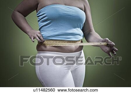 Woman measuring her waistline View Large Photo Image Stock Image - Woman measuring her waistline. Fotosearch