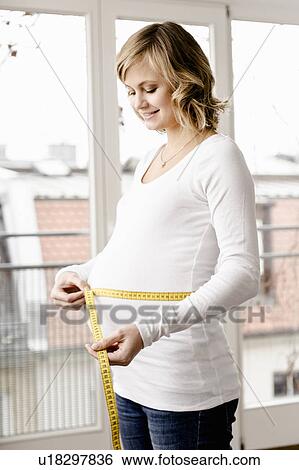 Woman measuring pregnant belly View Large Photo Image Stock Photograph - Woman measuring pregnant belly. Fotosearch