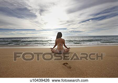Woman meditating on sandy beach View Large Photo Image Stock Photograph - Woman meditating on sandy beach. Fotosearch