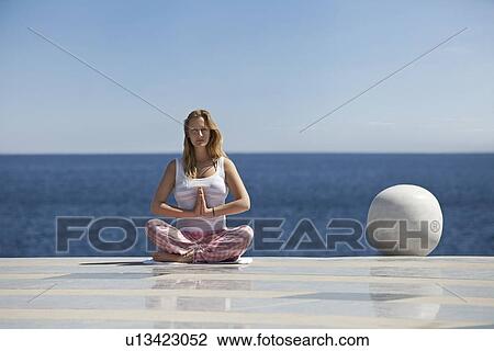 Woman meditating on tiled surface View Large Photo Image Stock Image - Woman meditating on tiled surface. Fotosearch