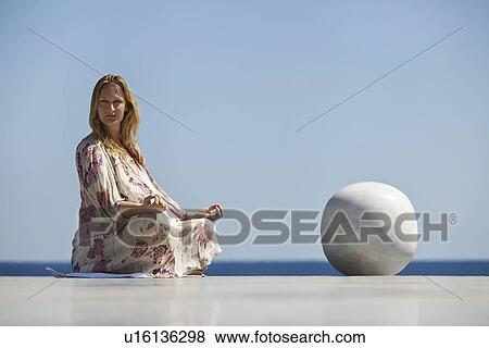 Woman meditating on tiled surface View Large Photo Image Stock Photo - Woman meditating on tiled surface. Fotosearch