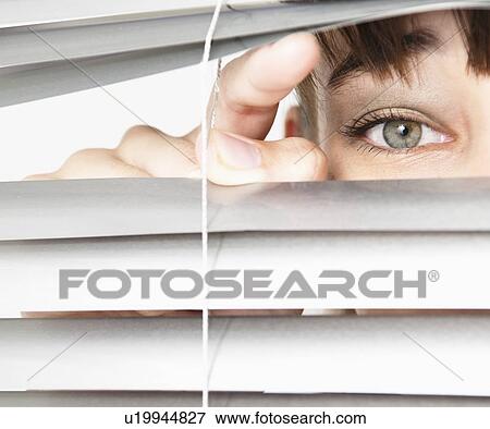Stock Photo - Woman peeking through blinds. Fotosearch