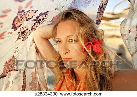 Stock Image - Woman playing with fabric on beach. Fotosearch