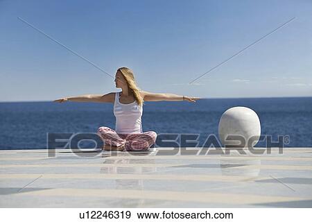 Woman practicing yoga on tiled surface View Large Photo Image Stock Photo - Woman practicing yoga on tiled surface. Fotosearch