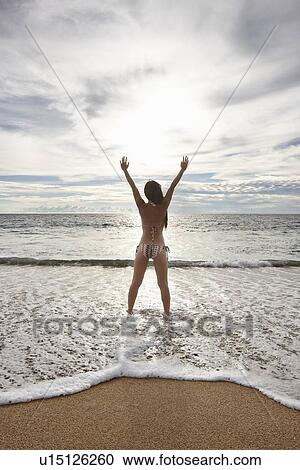 Woman standing in surf on beach View Large Photo Image Stock Image - Woman standing in surf on beach. Fotosearch