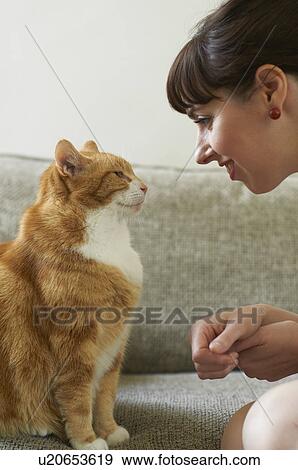 Woman talking with cat on sofa View Large Photo Image Stock Photo - Woman talking with cat on sofa. Fotosearch