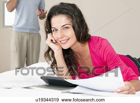 Woman using calculator on bed View Large Photo Image Stock Photo - Woman using calculator on bed. Fotosearch