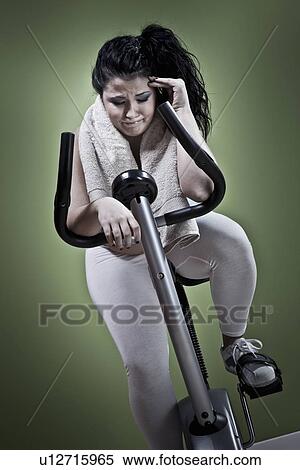 Woman using exercise bike at home View Large Photo Image Stock Photography - Woman using exercise bike at home. Fotosearch