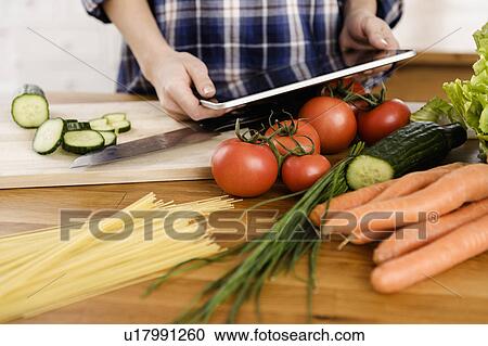 Woman using tablet computer to cook View Large Photo Image Stock Image - Woman using tablet computer to cook. Fotosearch